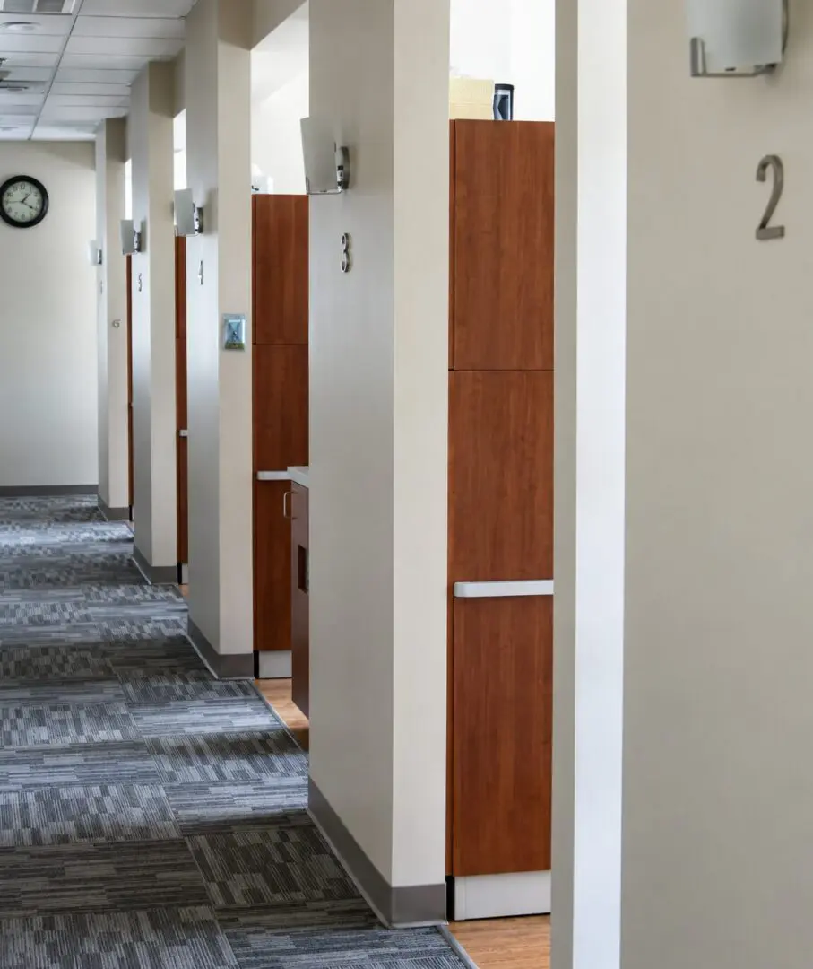 Hallway with numbered wooden doors and carpet.