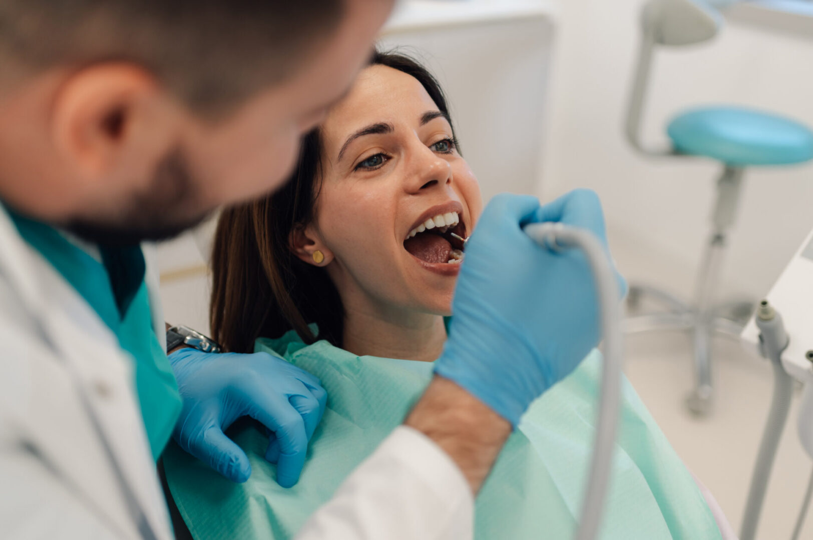 Dentist examining a patient's open mouth.